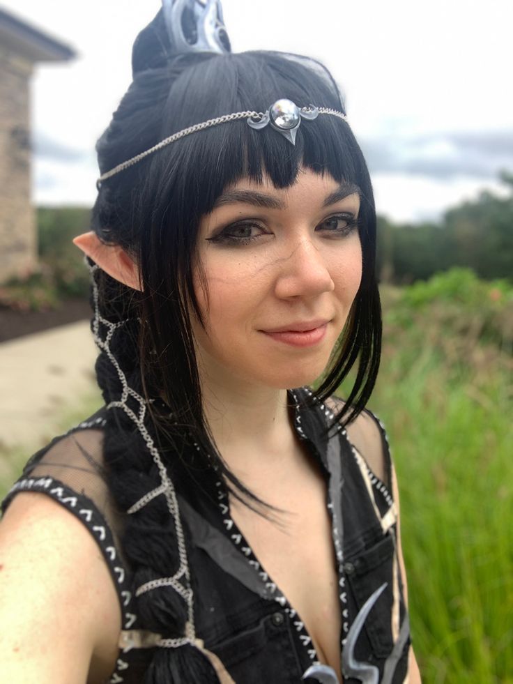 a woman with black hair wearing a costume and cat ears on top of her head