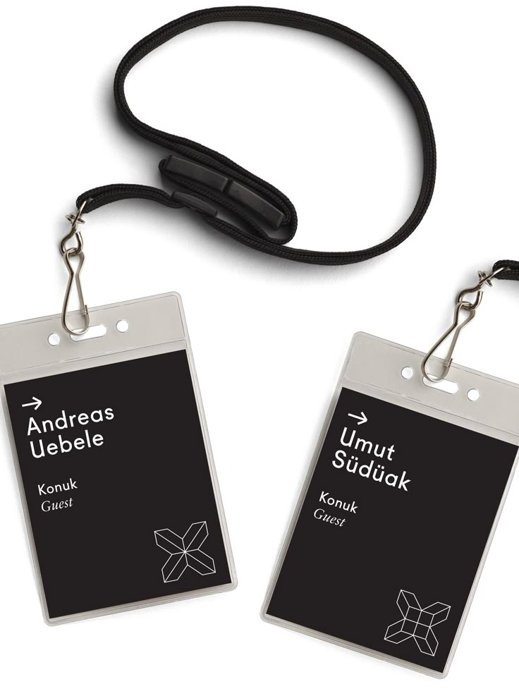 two lanyards are attached to each other with black cords and white tags on them