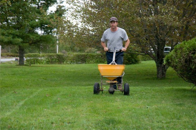 a man is pushing a yellow wagon in the grass