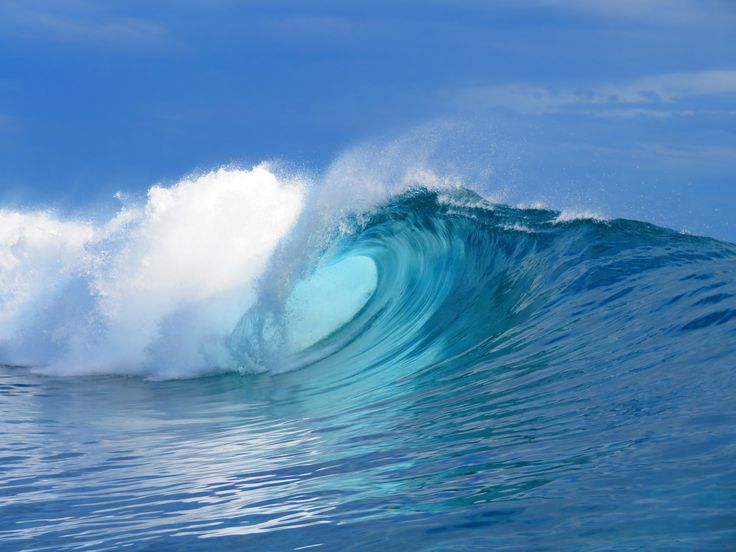 a large blue wave is breaking in the ocean