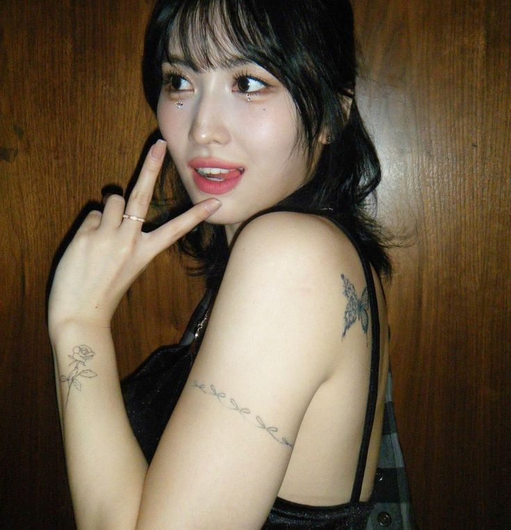 a woman with tattoos on her arm posing for the camera