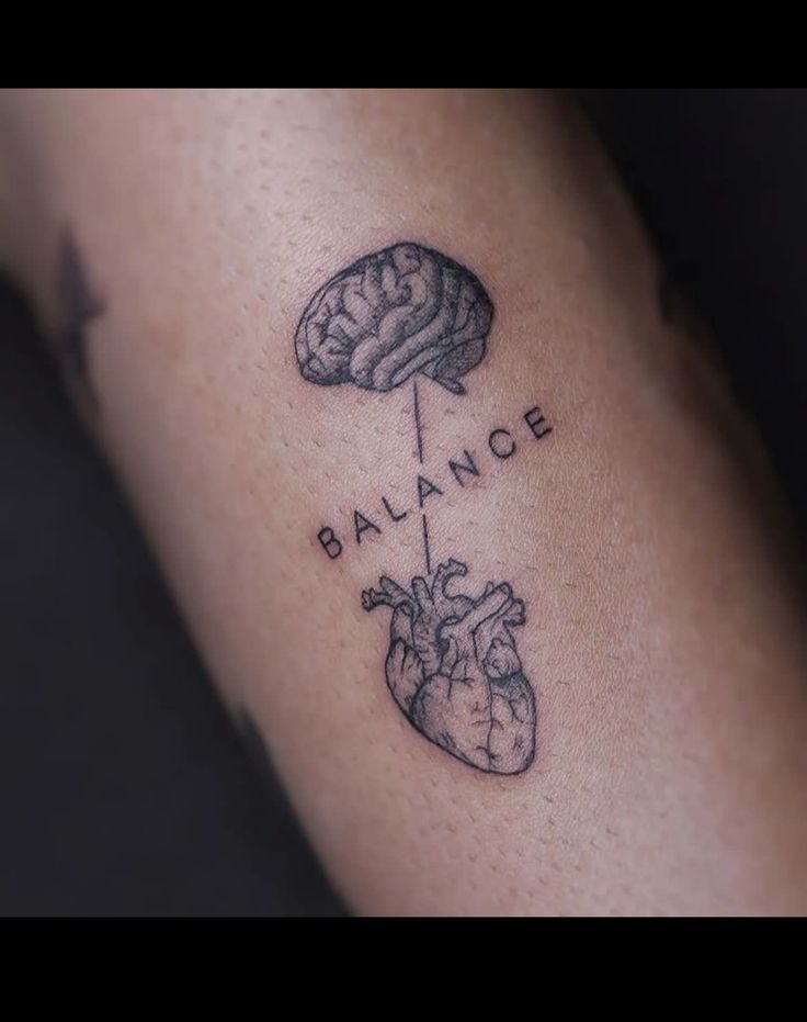 a tattoo on the arm that says balance and a heart with a brain in it