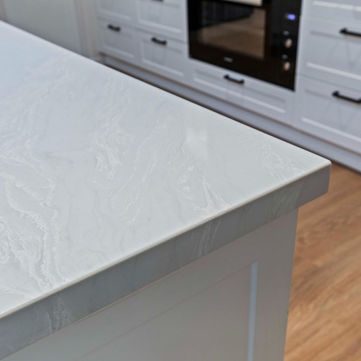 a white counter top in a kitchen next to an oven