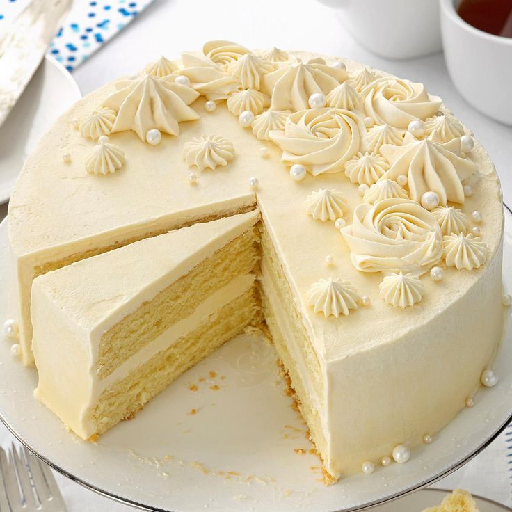 a white cake on a plate with one slice cut out and the rest half eaten