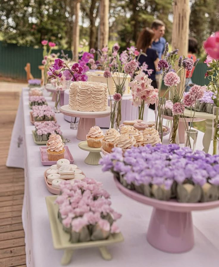 a table topped with lots of cakes and cupcakes