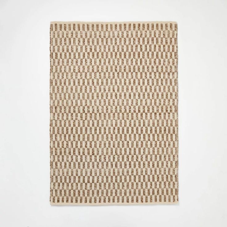 a brown and white square rug on a white wall with an abstract pattern in the middle