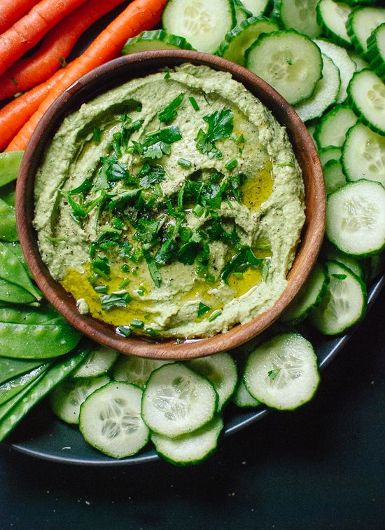 a plate topped with cucumber, carrots and hummus