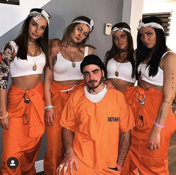 a group of women in orange prison uniforms posing for a photo with one man wearing an orange prison uniform