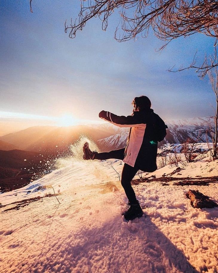 a man standing on top of a snow covered slope