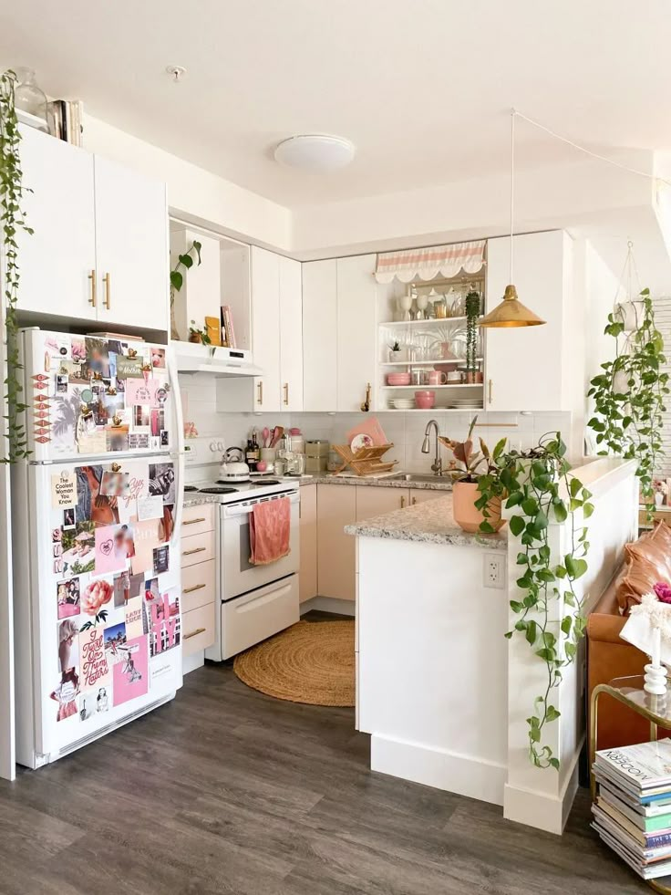 a kitchen with white appliances and lots of plants