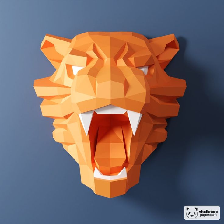 an orange paper sculpture of a tiger's head with its mouth open and it's teeth wide open