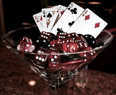 a glass bowl filled with dice and playing cards