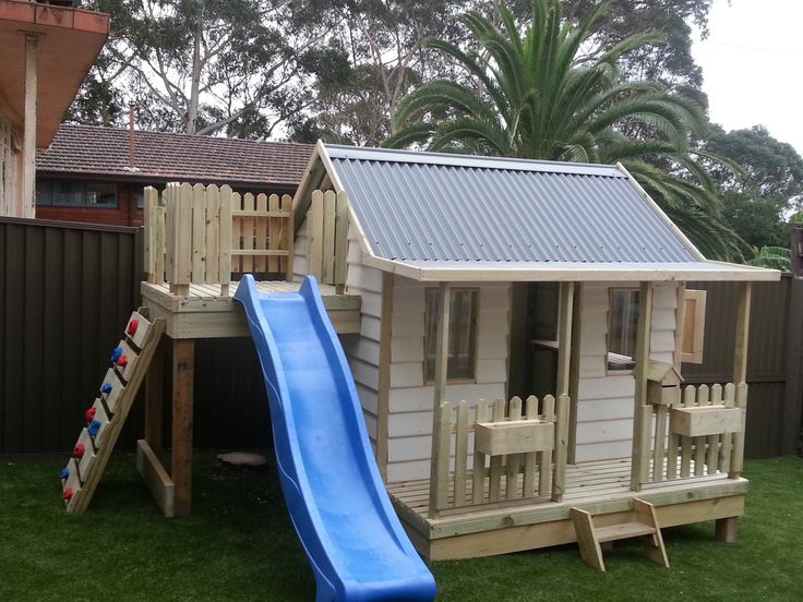 a small house with a slide in the yard