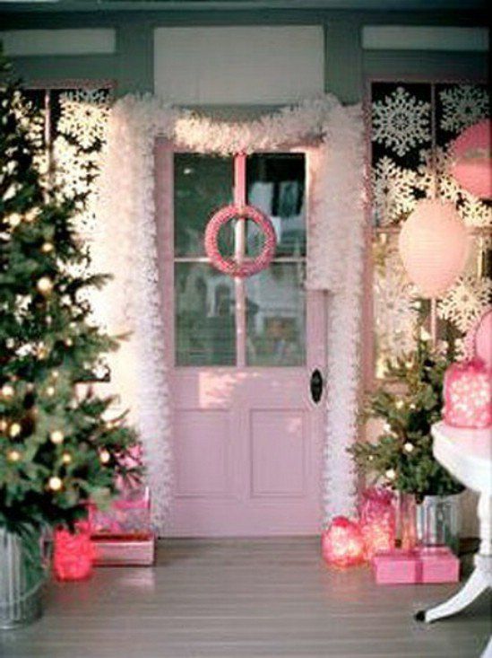 the front door is decorated with pink and white christmas trees, presents, and wreaths