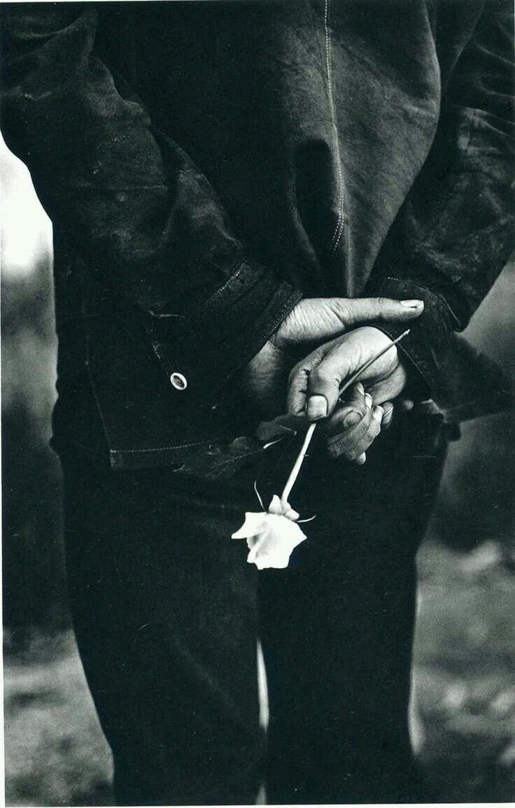 a black and white photo of a person holding a flower