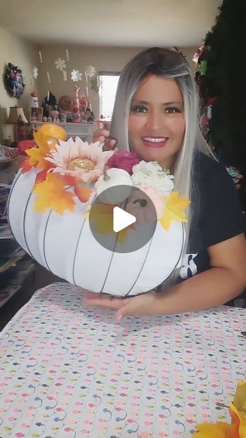 a woman is holding up a large paper flower arrangement in her hands and smiling at the camera