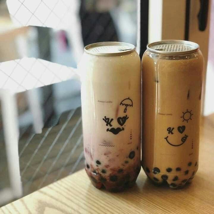 two jars sitting on top of a wooden table next to each other with drinks in them