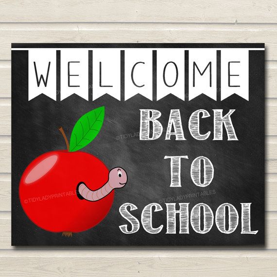 welcome back to school sign with an apple and worm on the front, blackboard background