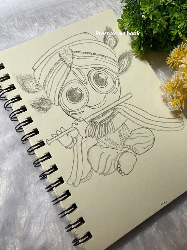 a notebook with a drawing on it next to flowers