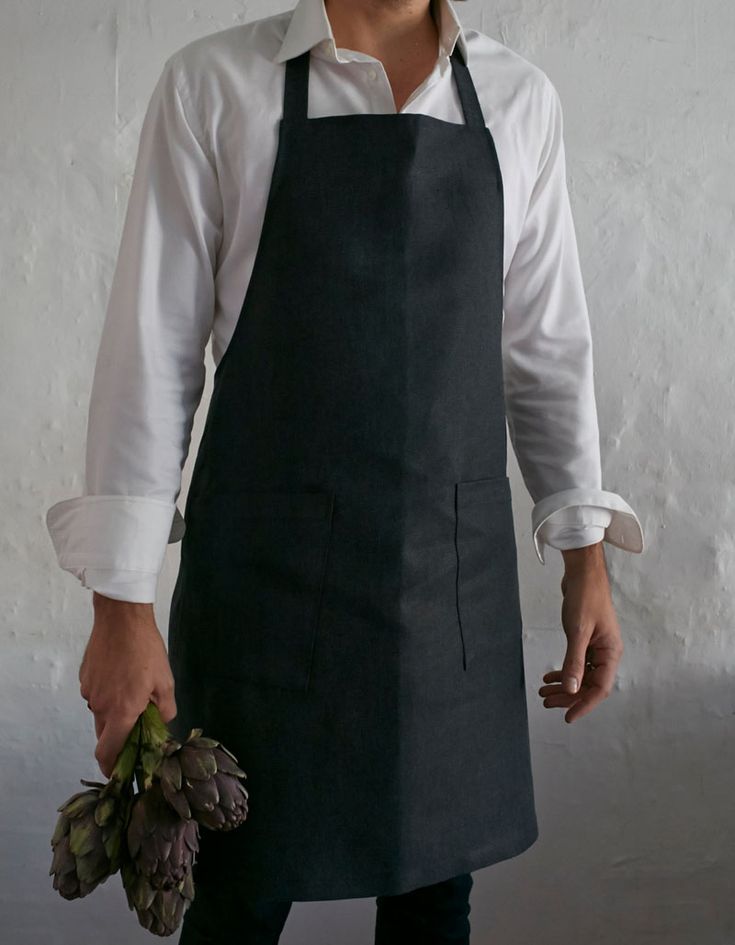 a man wearing an apron and holding a flower