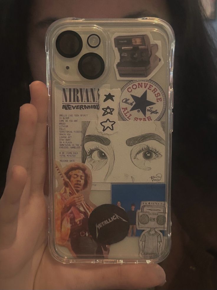 a person holding up a clear case with various stickers on the back of it