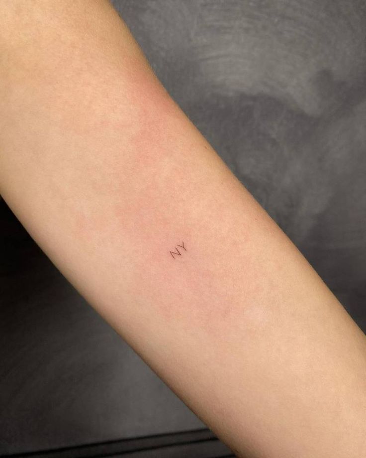 a woman's arm with a small tattoo on the left side of her arm