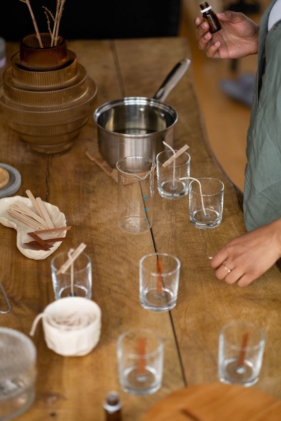 a table with several glasses and utensils on it, including one being filled with liquid