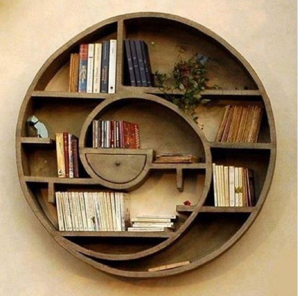 a circular shelf with books on it and a plant in the middle is mounted to the wall