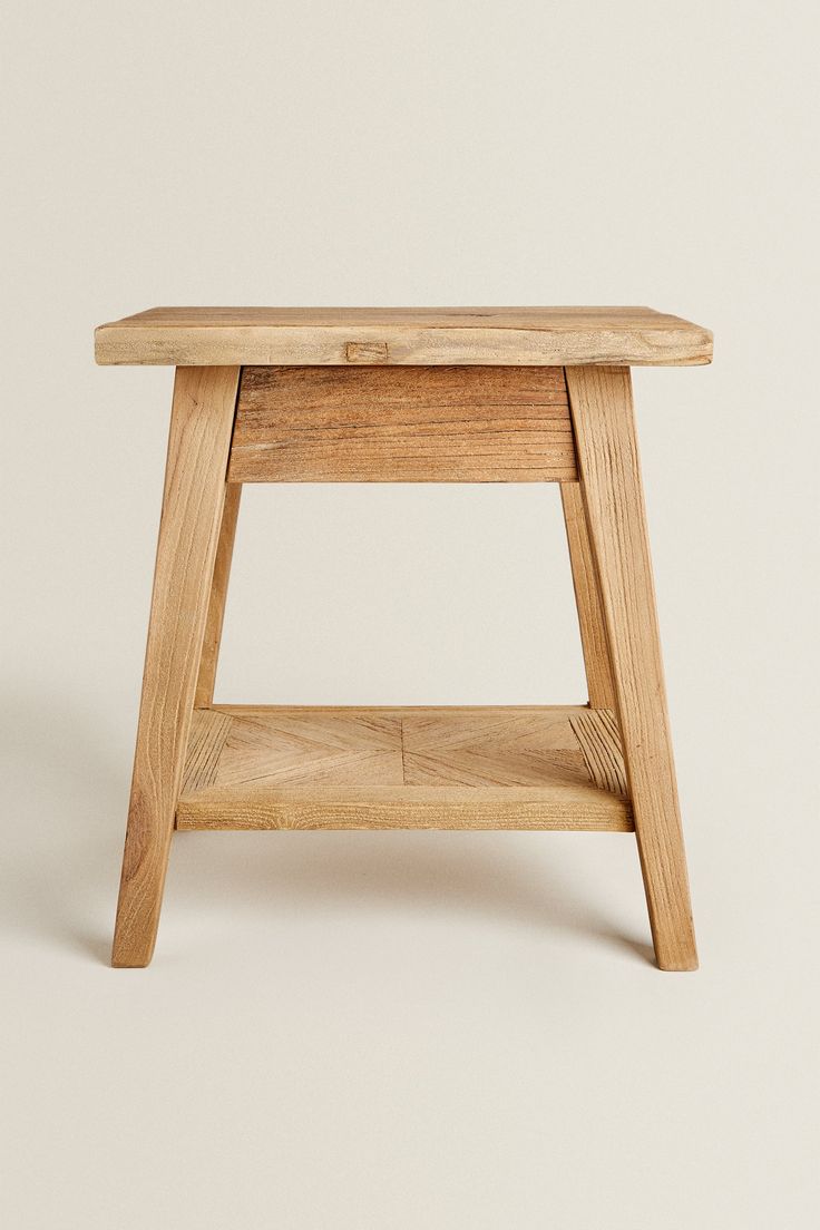 a small wooden stool sitting on top of a white floor