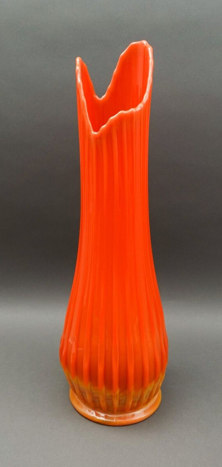 an orange vase sitting on top of a table