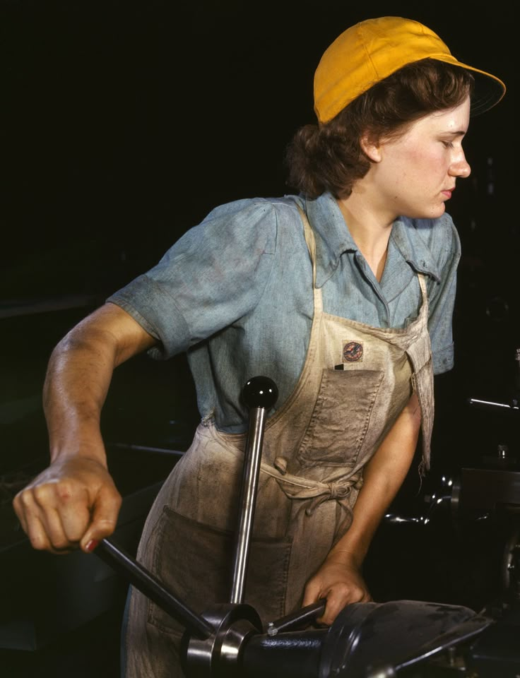 a man in overalls and a yellow hat is holding a wrench while looking at something on the screen