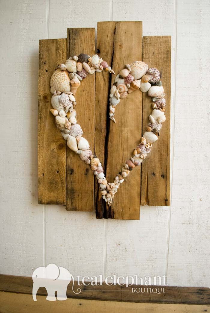 a heart made out of seashells hangs on a wall