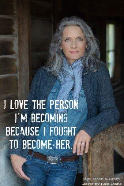 a woman with grey hair wearing jeans and a blue shirt