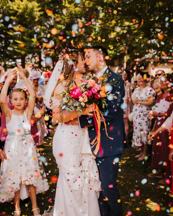 a bride and groom are surrounded by confetti