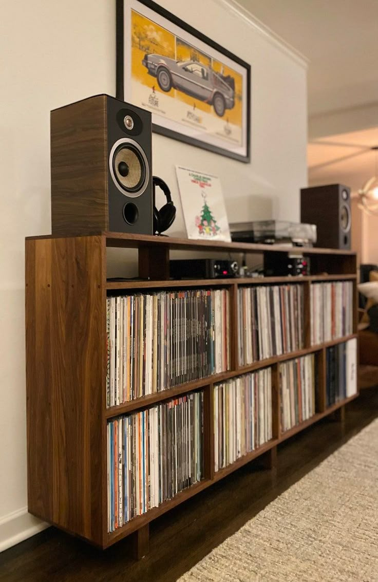 a record player sitting on top of a wooden shelf next to a wall mounted stereo