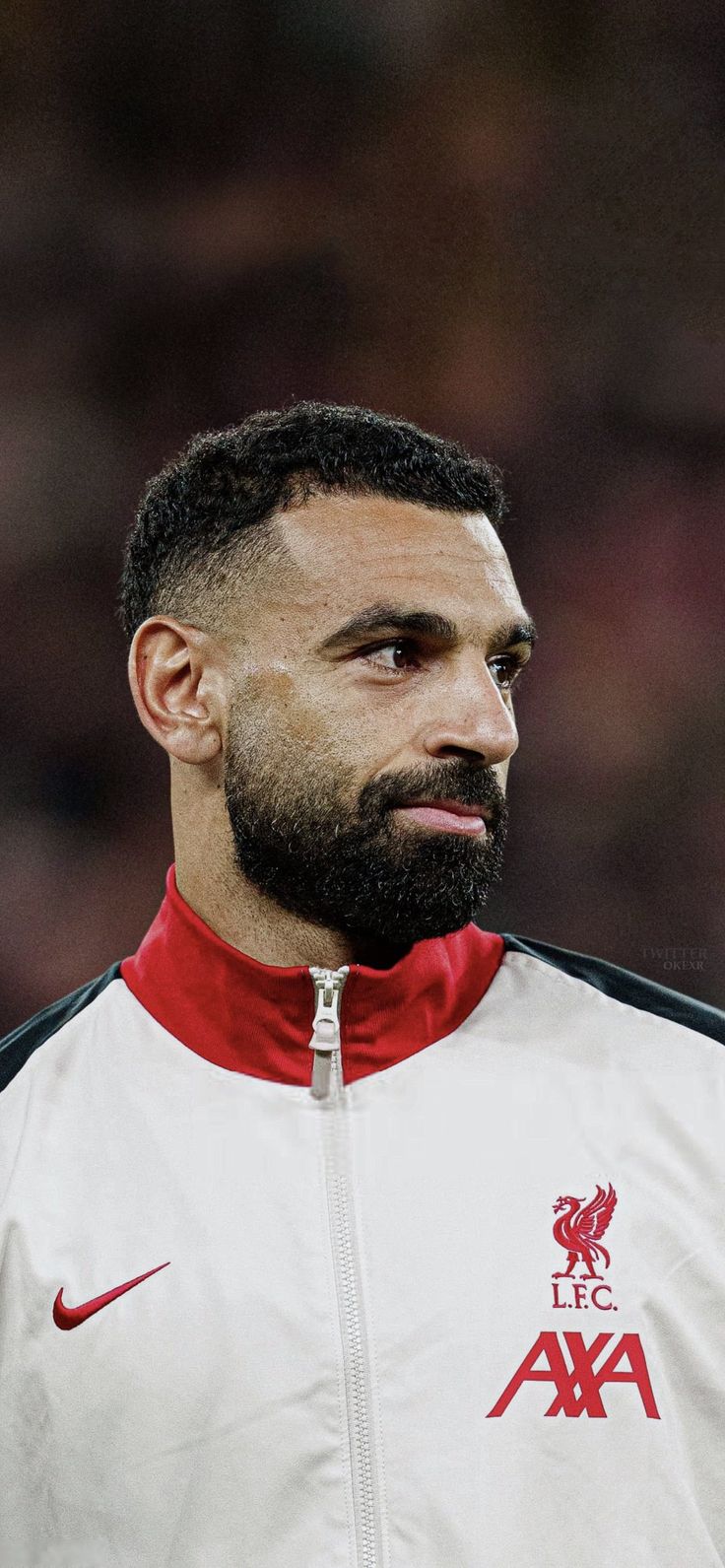 a man with a beard wearing a white and red jacket