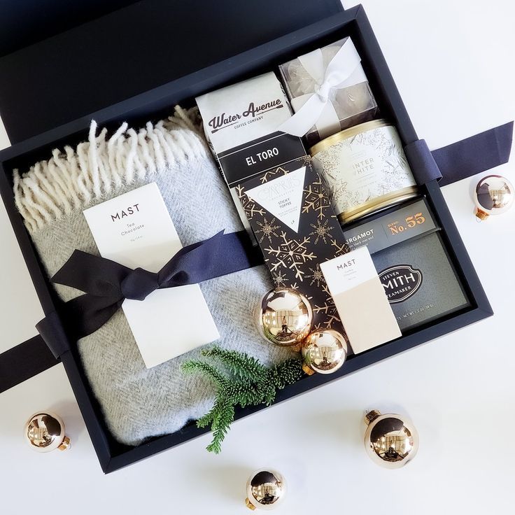 an open box with various items in it sitting on a table next to christmas decorations