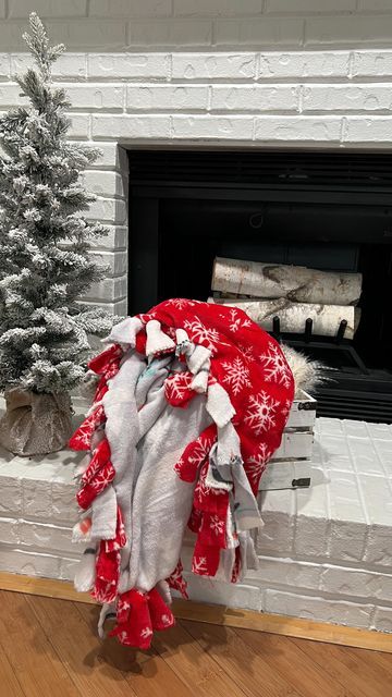 a christmas tree sitting in front of a fire place with a blanket over it's head