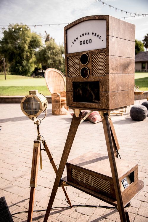 an old fashioned camera sitting on top of a tripod in the middle of a park