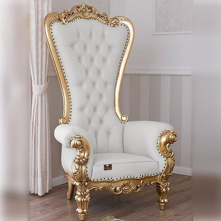 an ornate white and gold chair in a room with wood flooring on the side