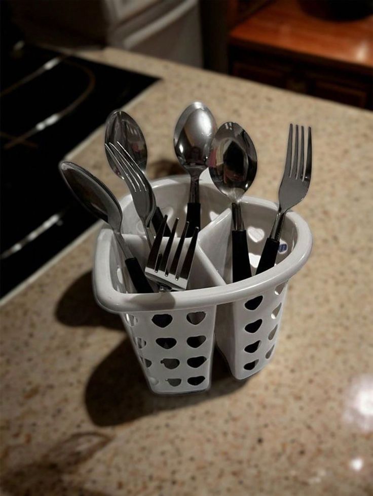 a cup filled with forks and spoons on top of a counter