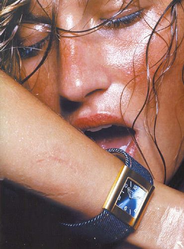 a close up of a person wearing a watch on her wrist with water all over her face