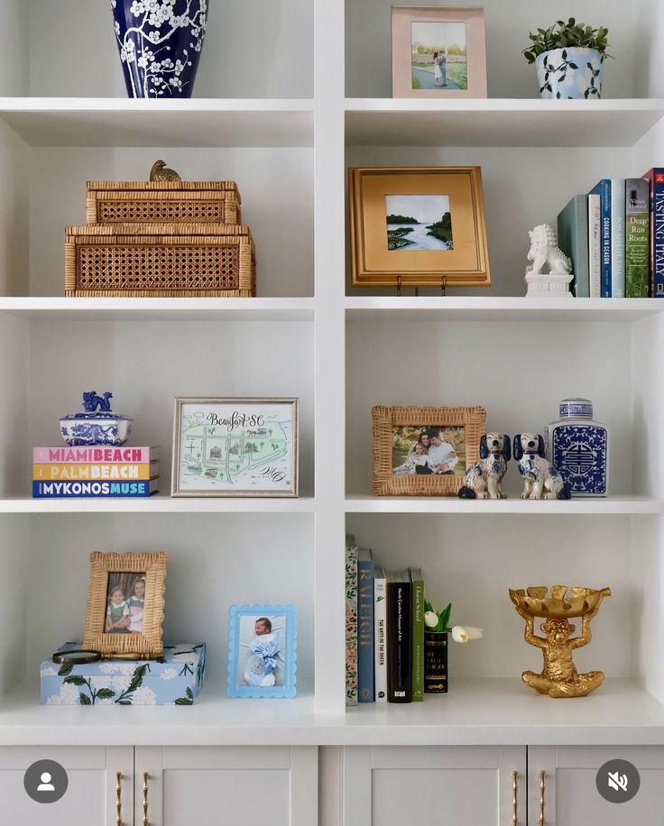 a white book shelf with many books and pictures on it's sides, along with other decorative items