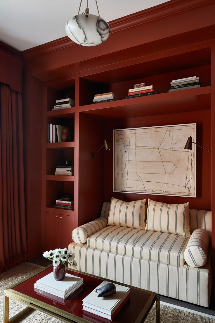 an image of a living room with red walls and bookshelves on the shelves