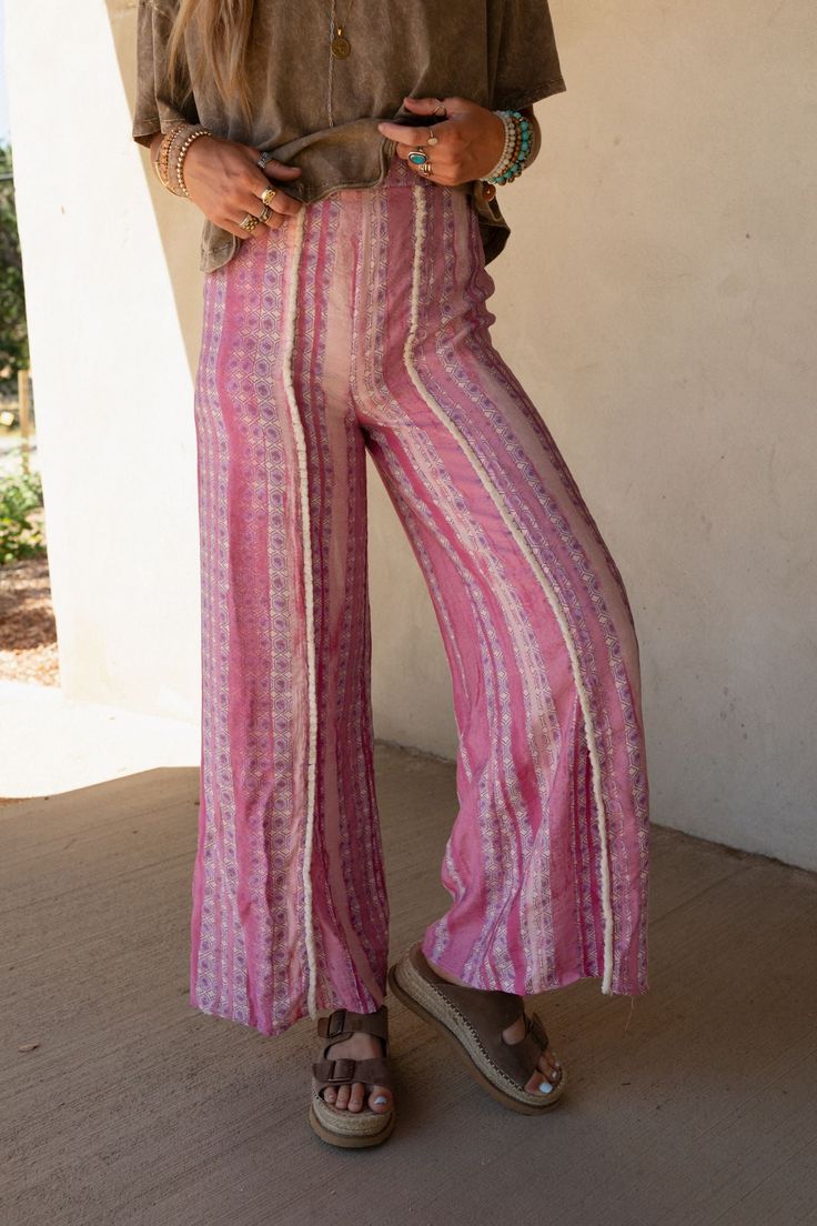 Effortlessly Cool and boho-chic you're never going to want to take the Walk The Line Wide Leg Pants off and they are the perfect addition to your wardrobe from this season to the next! Flowy, lightweight woven fabric with an eye-catching geometric striped print Relaxed and loose wide leg silhouette with a so CUTE trim center seam Flattering high-rise elastic waistband Unique mini bottom front slits for added style Pair with: Audra Waistband Loop Lace Bralette,Shirr Delight Puff Sleeve Top and Co Summer Vacation Boho Print Bottoms, Bohemian Summer Bottoms For Day Out, Bohemian Rayon Bottoms For Summer, Bohemian Ankle-length Wide Leg Pants For Vacation, Bohemian Style Rayon Bottoms For Summer, Hippie Boho Print Vacation Bottoms, Bohemian Wide Leg Rayon Pants For Vacation, Bohemian High-waisted Harem Pants For Vacation, Bohemian Rayon Wide Leg Pants For Vacation