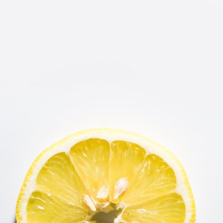 a lemon is cut in half on a white surface with the peel still attached to it