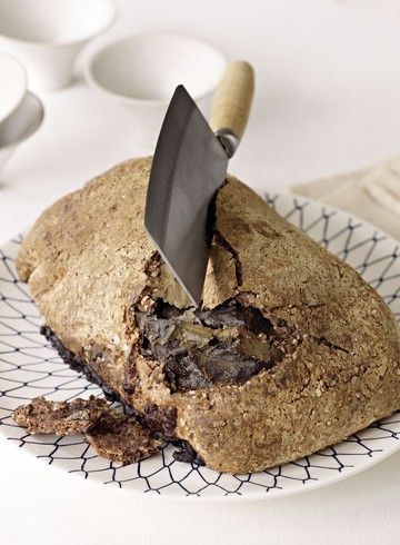 a knife cutting into a loaf of bread on a plate