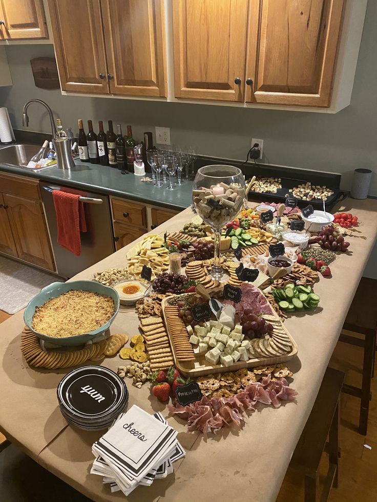 a kitchen counter covered in lots of food and wine glasses on top of the table