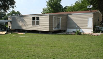 a mobile home sitting in the middle of a yard