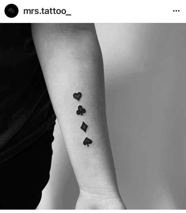 a person with a tattoo on their arm that has hearts and spades on it